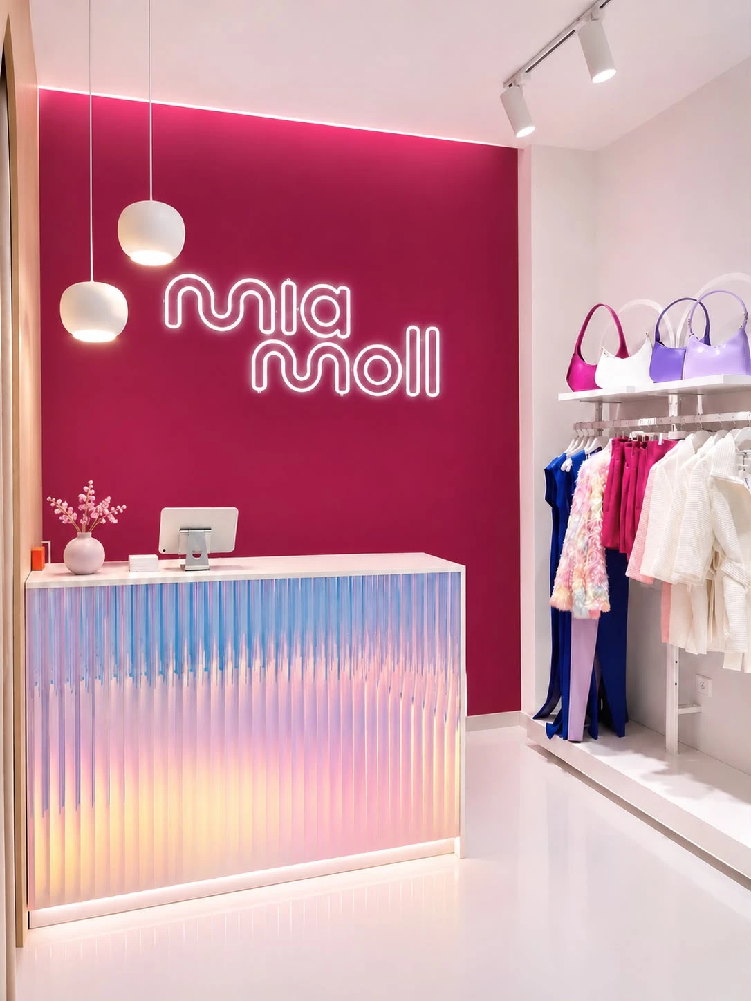 Le comptoir de la boutique avec le logo Mia Moll en néon sur le mur fuchsia
